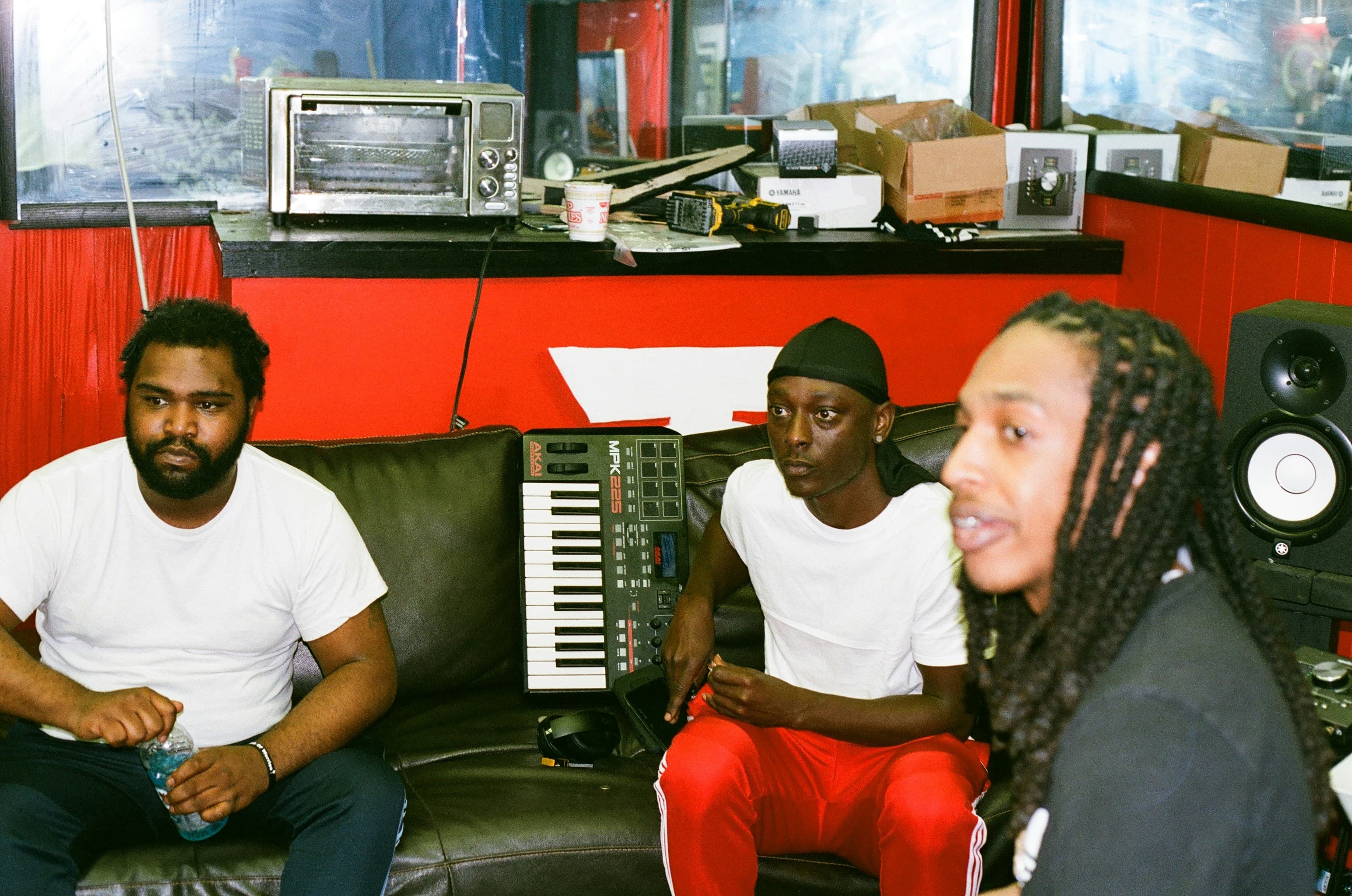 Musicians collaborating in a vibrant red studio