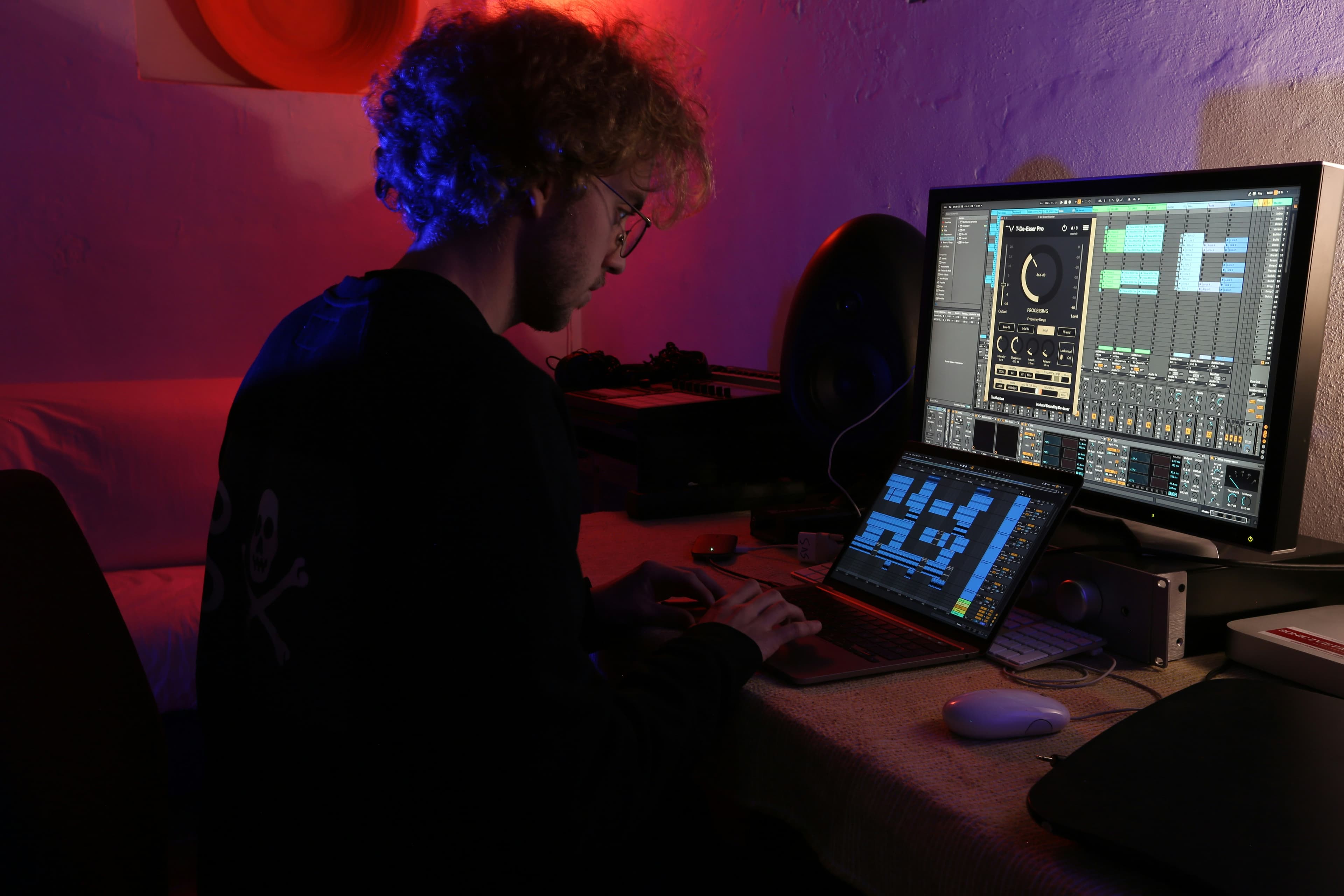 Producer working in neon-lit studio